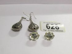 A pair of silver pendant earrings and a pair of silver stud earrings