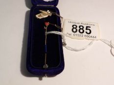 A cased gold stick pin with an hand brooch safety chain,