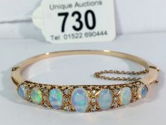 A superb opal and diamond bangle set in rose gold with very vibrant colours of opals