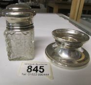 A silver candlestick and a silver topped scent bottle