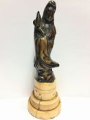 An 18th century Chinese bronze figure, Guanyin, on an ivory base,