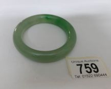 An apple green with dark green inclusions jadeite bangle