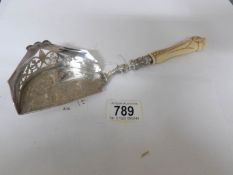 A very fine 19th century ornate white metal crumb scoop with piecework gallery and ivory handle