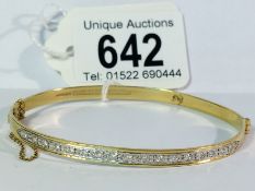 An 18ct gold bangle set with 17 brilliant cut diamonds, 11.