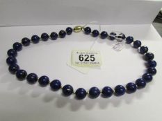 A necklace of lapis lasuli beads with silver clasp