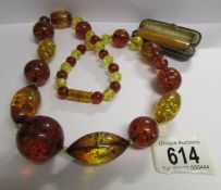 A necklace of large amber beads and an amber cigarette holder