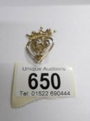 A 9ct gold brooch fashioned as a heart with a crown on top