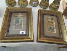A pair of framed and glazed hand painted panels of Asian scenes