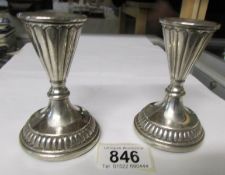 A pair of conical silver candlesticks
