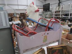 A vintage dolls cot and a rocking horse