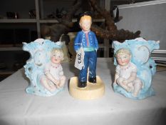 A pair of bisque porcelain spill vases and a figure of a boy