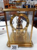 A brass and glass anniversary clock