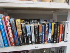 A shelf of books including Clive Cussler