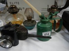 A quantity of vintage oil cans and oil lamps