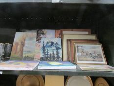 A shelf of assorted paintings and prints