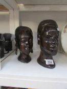 A tribal art male and female carved wooden heads (female repaired)