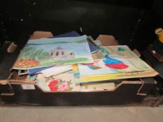 A box of unframed paintings