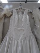 A white 'Mon Cherie Bridals Inc' wedding gown with decorative embroidered fitted bodice and full