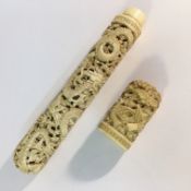 A carved bone cylindrical case with flora and fauna depictions