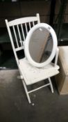 A white painted folding chair & white framed bathroom mirror