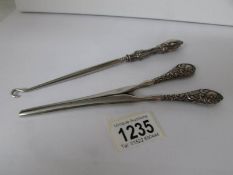 A pair of silver handled glove stretchers and a silver handled button hook