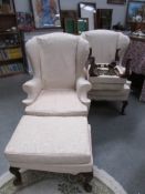 A pair of wing arm chairs and matching stools