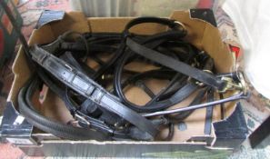 A box of leather bridles etc