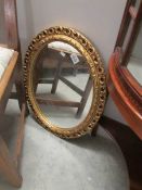 An oval gilt framed mirror