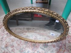 An oval gilt framed mirror