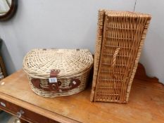 A wicker picnic basket with contents and another wicker basket