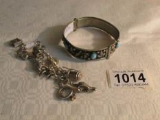 A silver charm bracelet together with a silver and turquoise bangle