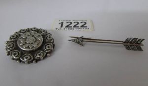 A silver arrow brooch and an embossed silver brooch