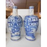 A large pair of rare shaped 19th century blue and white vases depicting a large house,