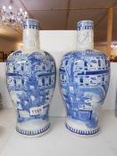 A large pair of rare shaped 19th century blue and white vases depicting a large house,