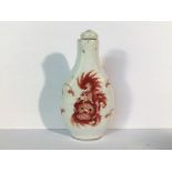 A circa 20th century iron red snuff bottle depicting pug dogs with a Ju Ren Tang mark