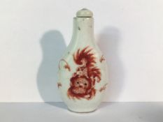 A circa 20th century iron red snuff bottle depicting pug dogs with a Ju Ren Tang mark