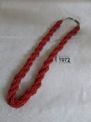 A coral coloured long necklace