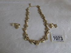 A Trifari necklace and matching earrings fashioned as ribbons