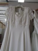 A 'Mon Cherie Bridal Inc' wedding gown with beaded bodice and skirt flowing in to train,