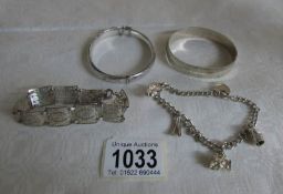 2 silver bangles, a silver charm bracelet and a silver bracelet,