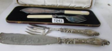 A cased pair of fish servers and one other pair