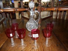 A cut glass claret jug and 6 cranberry goblets on clear stems