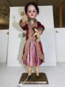 A Victorian bisque automaton doll in original clothing and in working order
