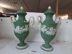 A pair of 19th century lidded vases with rams head handles,