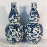 A pair of circa 19th century blue and white double gourd vases with depictions of birds and fauna