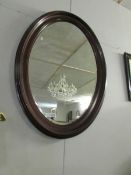 A large oval mahogany framed bevel edged mirror