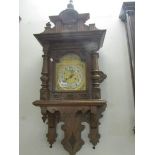 An oak wall clock with brass face