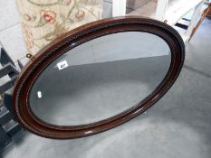 A large oval framed bevel edged mirror