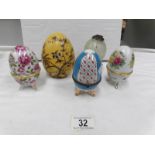 A hand decorated ceramic egg together with 3 egg shaped trinket pots and a glass hanging egg