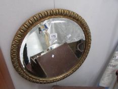 A circular gilt framed mirror